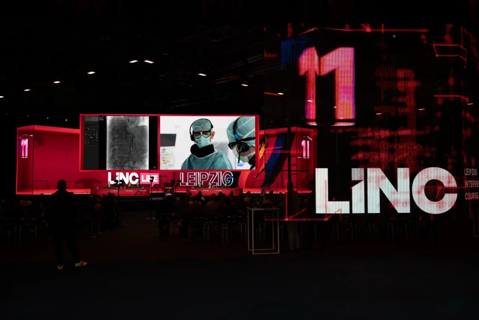 The main arena at LINC 2026 during a live surgery broadcast, with attendees watching the procedure on a large screen