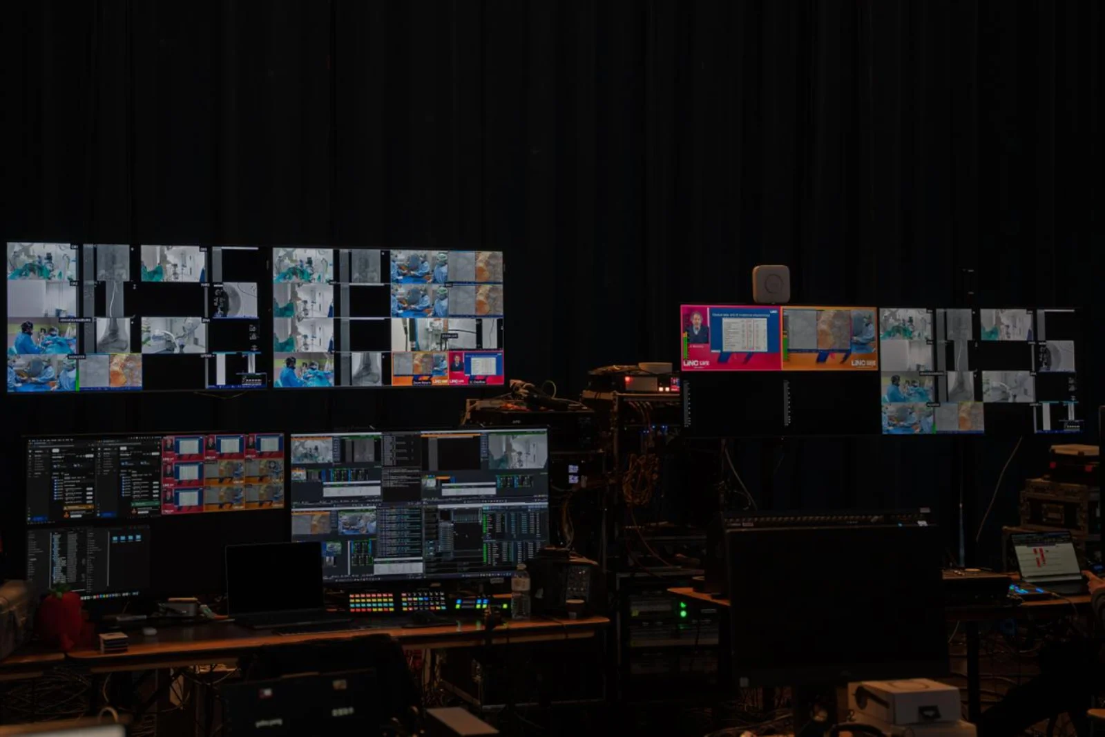 The master control room at LINC 2026 with walls of monitors showing live surgery feeds and mixing desks